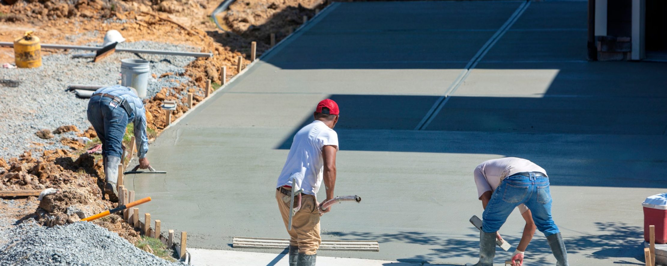 Unidentifiable,Hispanic,Men,Working,On,A,New,Concrete,Driveway,At